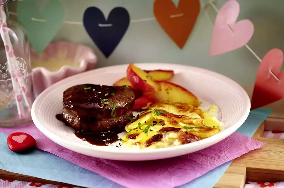 Fillet steak in red wine sauce with potato gratin and love apple